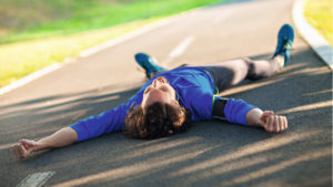 Man lying on running track after HIIT workout