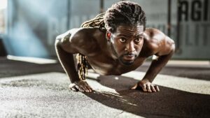 Athlete exercising push-ups in a gym.